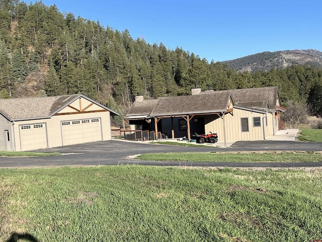 250 Sunset Ln, Durango, CO 81301 - view of front of home featuring board and batten siding, a mountain view, a front lawn, and a detached garage