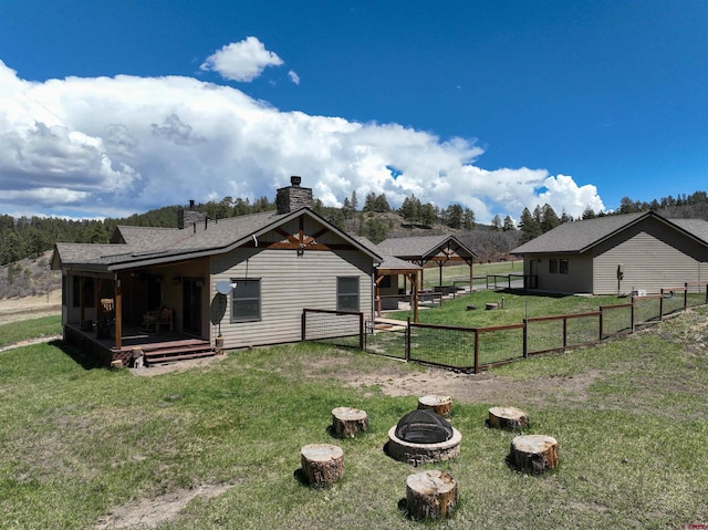 250 Sunset Ln, Durango, CO 81301 - rear view of house with a gazebo, fence, a chimney, a lawn, and an outdoor fire pit