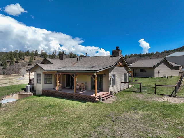 250 Sunset Ln, Durango, CO 81301 - rear view of property featuring a gate, fence, a chimney, a lawn, and central AC unit