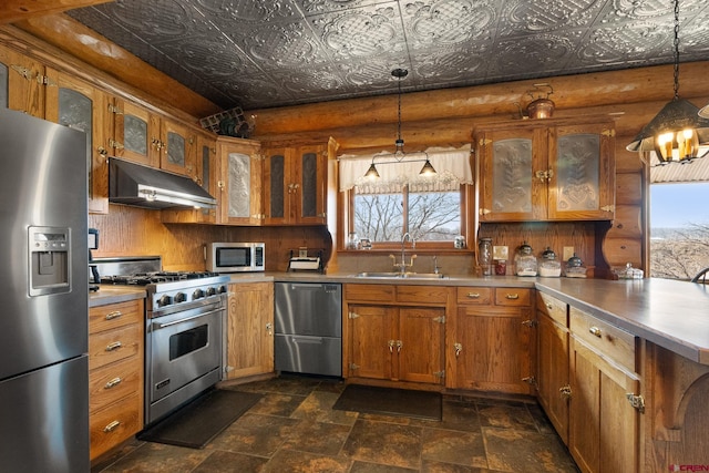 kitchen with brown cabinetry, an ornate ceiling, appliances with stainless steel finishes, under cabinet range hood, and a sink