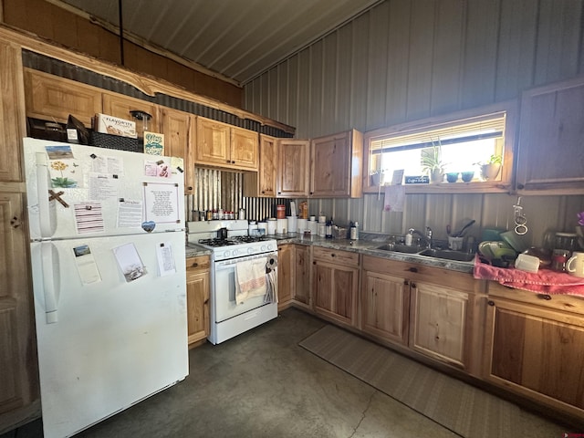 kitchen featuring concrete flooring, white appliances, a sink, brown cabinets, and dark countertops