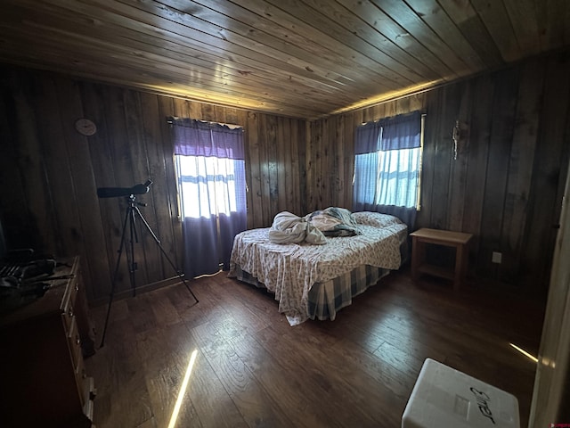 bedroom with dark wood-type flooring, wooden ceiling, and wooden walls