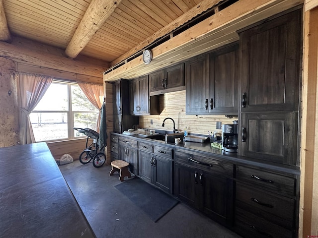 kitchen with dark countertops, dark brown cabinetry, beam ceiling, and a sink