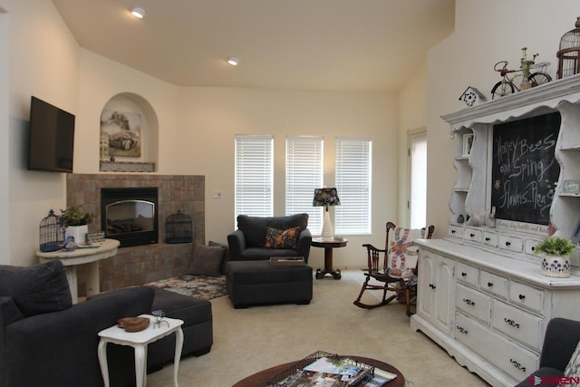 living area with recessed lighting, light colored carpet, and a tiled fireplace