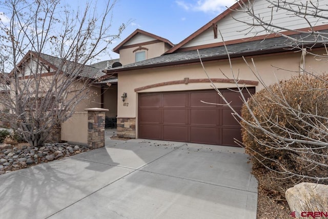 view of front of home featuring driveway, stone siding, a shingled roof, and stucco siding