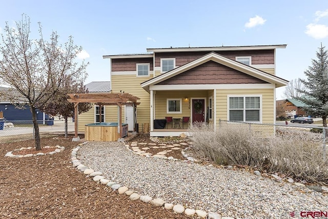 view of front of property featuring a patio area, fence, a hot tub, and a pergola