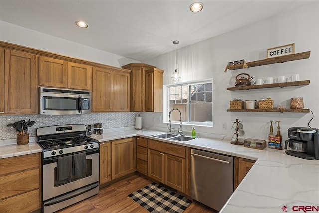 kitchen with stainless steel appliances, a sink, decorative backsplash, open shelves, and decorative light fixtures