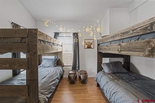 bedroom with baseboards and wood finished floors