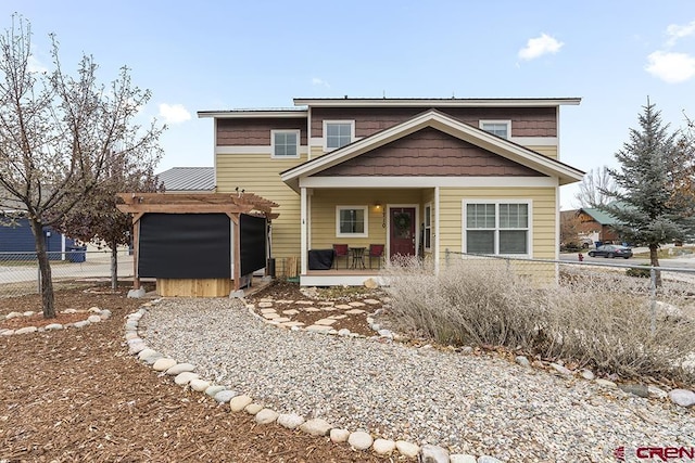 view of front of home with a pergola, fence, and a hot tub