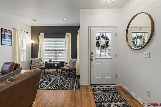 entryway with a healthy amount of sunlight, baseboards, and wood finished floors