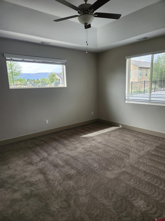 unfurnished room with carpet, visible vents, and baseboards