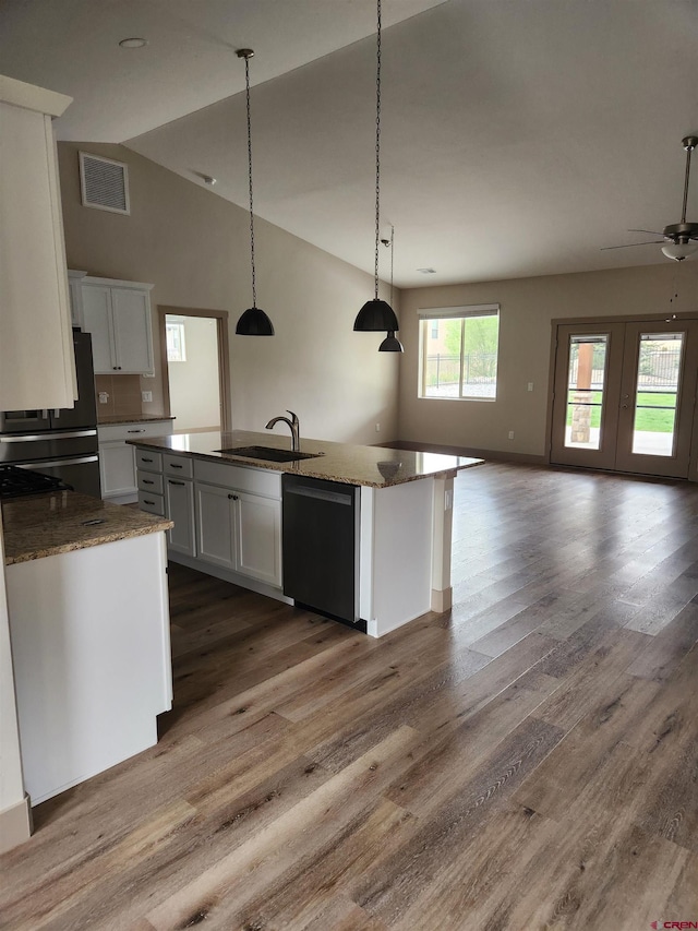 kitchen with black appliances, visible vents, white cabinetry, and open floor plan