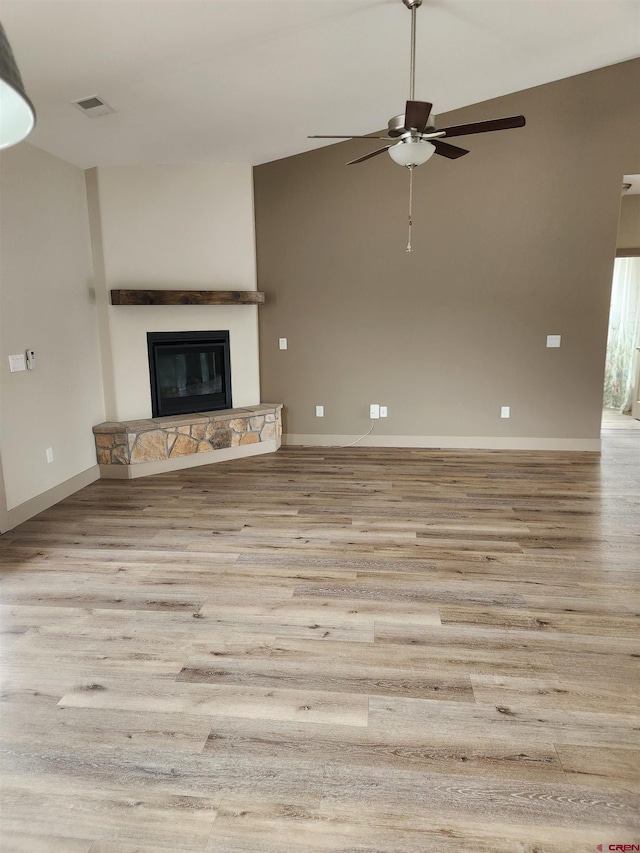 unfurnished living room with light wood-type flooring, baseboards, a fireplace, and visible vents