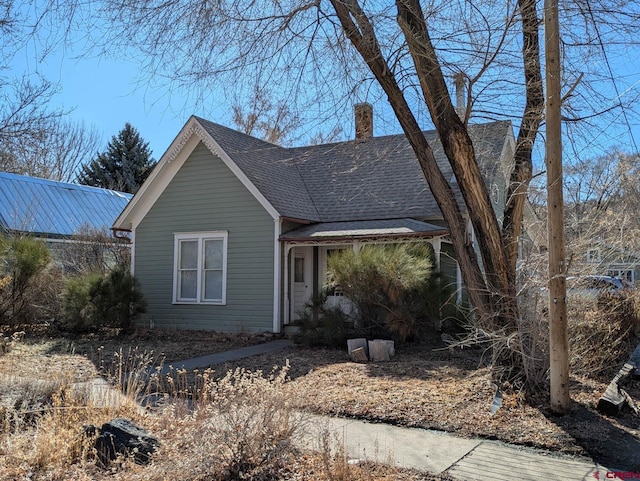 view of front of home featuring roof with shingles and a chimney