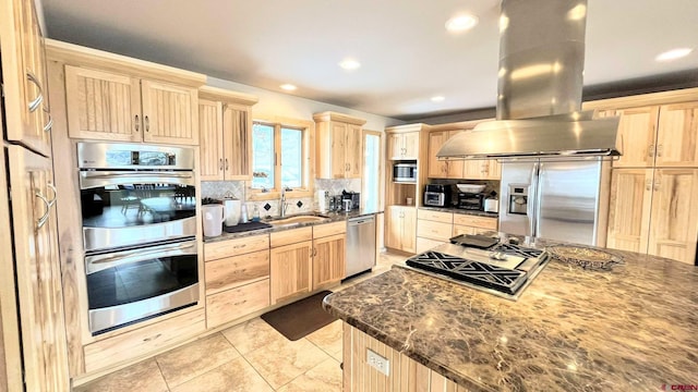 kitchen with dark stone counters, light brown cabinetry, appliances with stainless steel finishes, and island exhaust hood