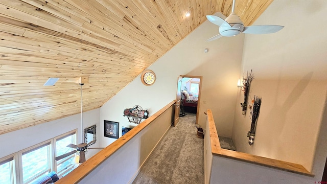 hallway with carpet floors, wooden ceiling, high vaulted ceiling, and an upstairs landing