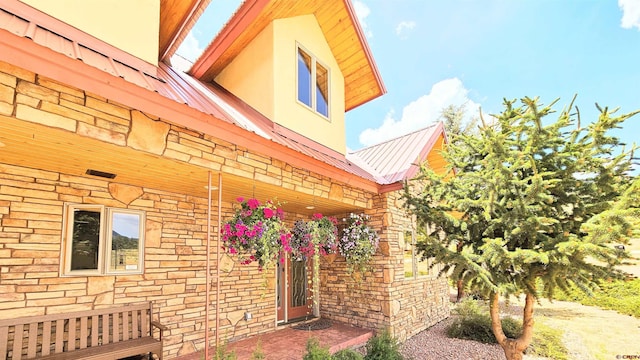 entrance to property featuring metal roof and brick siding