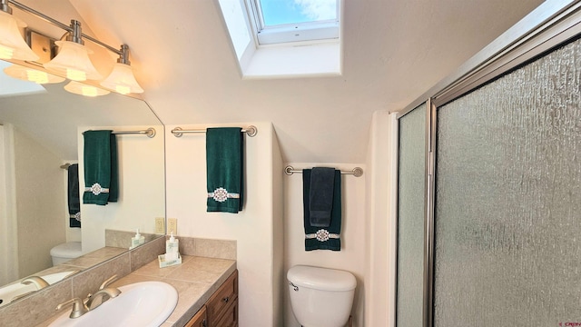 bathroom with toilet, a skylight, a shower stall, and vanity