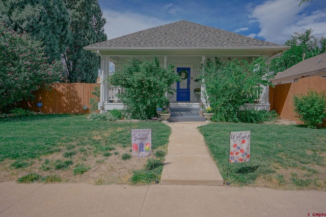 bungalow-style house with a front lawn, a shingled roof, and fence