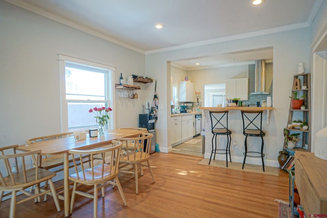 dining space with crown molding, recessed lighting, baseboards, and light wood-style floors