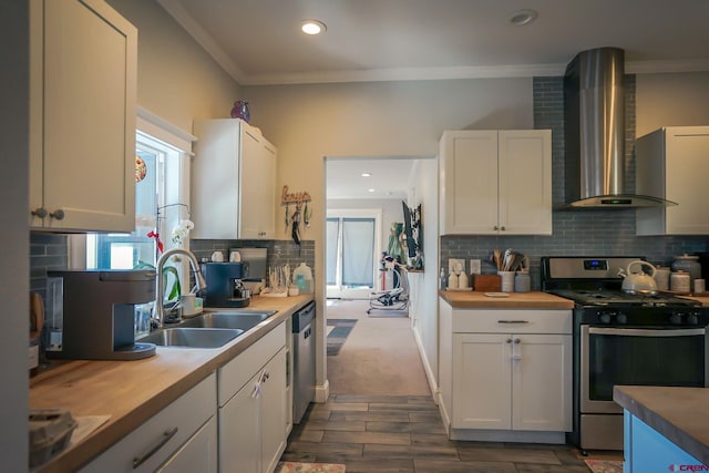 kitchen featuring stainless steel appliances, white cabinetry, and wall chimney range hood