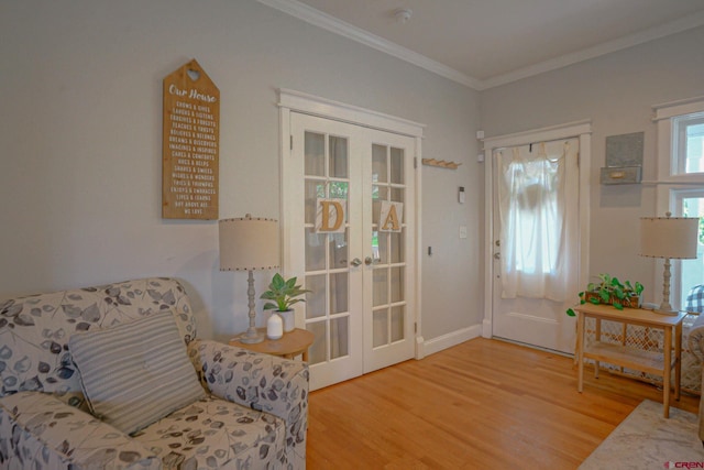 living area with baseboards, french doors, wood finished floors, and crown molding