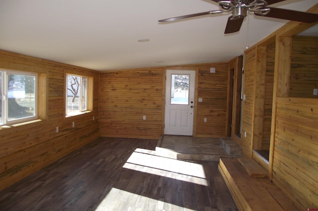 foyer with lofted ceiling, dark wood finished floors, and wooden walls