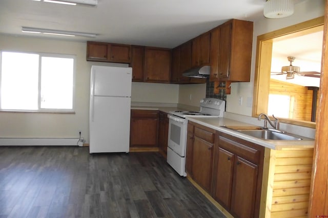 kitchen with under cabinet range hood, white appliances, a sink, light countertops, and baseboard heating