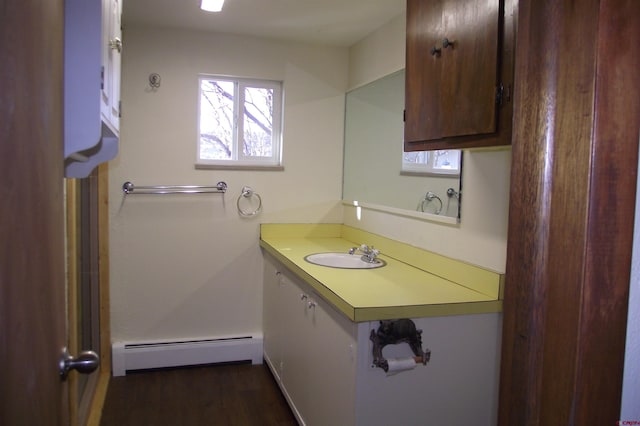 bathroom with a baseboard radiator, wood finished floors, and vanity