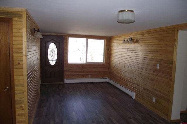 foyer with a baseboard radiator, dark wood finished floors, and wooden walls