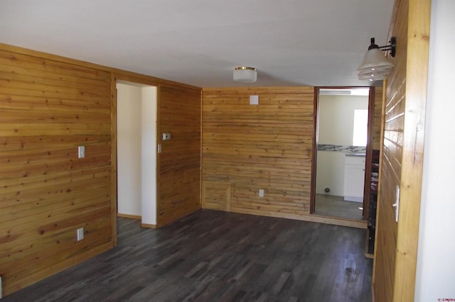 spare room featuring dark wood-style floors and wood walls