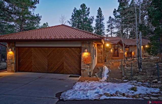 380 Marmot Dr, Ridgway, CO 81432 - view of front of home with a tile roof, concrete driveway, an attached garage, and stone siding