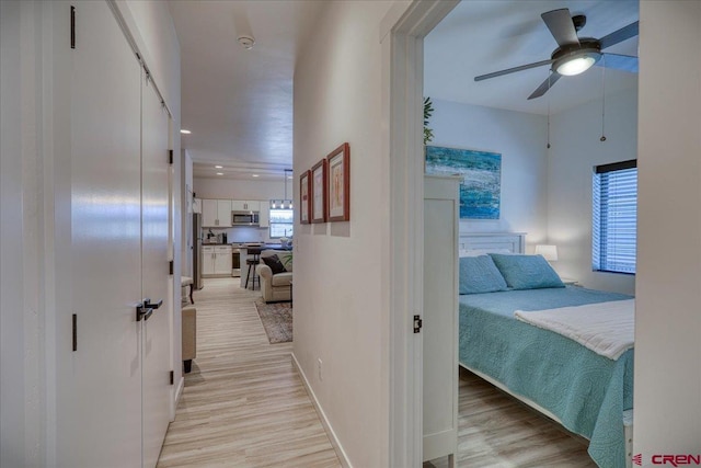 hall featuring recessed lighting, light wood-style flooring, and baseboards