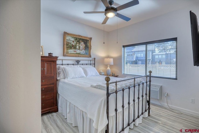 bedroom with a ceiling fan, light wood-style flooring, and baseboards