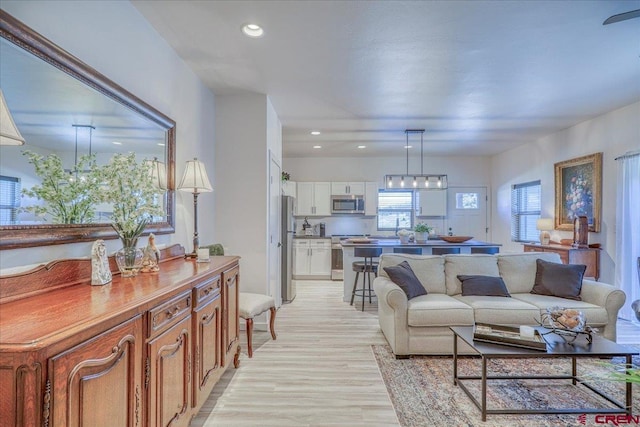 living area featuring light wood-type flooring and recessed lighting