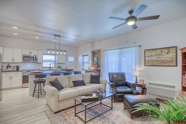 living room featuring light wood-style floors, recessed lighting, a ceiling fan, and a wall mounted AC