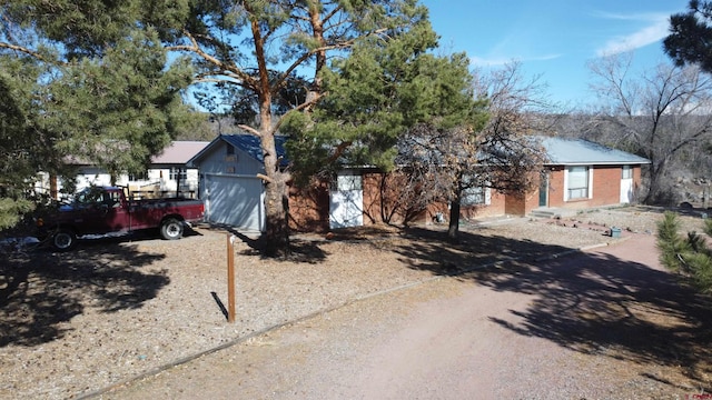 view of front facade featuring brick siding, driveway, and an attached garage