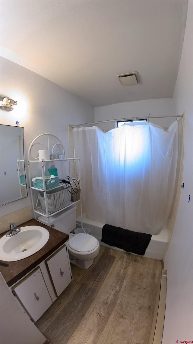 bathroom featuring visible vents, toilet, a baseboard radiator, shower / bath combination with curtain, and vanity