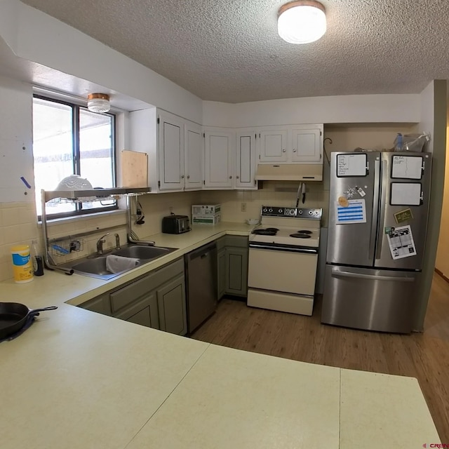 kitchen featuring white range with electric cooktop, dishwashing machine, freestanding refrigerator, under cabinet range hood, and a sink