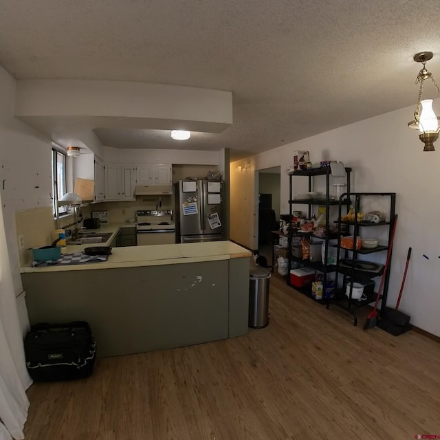 kitchen with electric range, white cabinets, decorative light fixtures, freestanding refrigerator, and light countertops