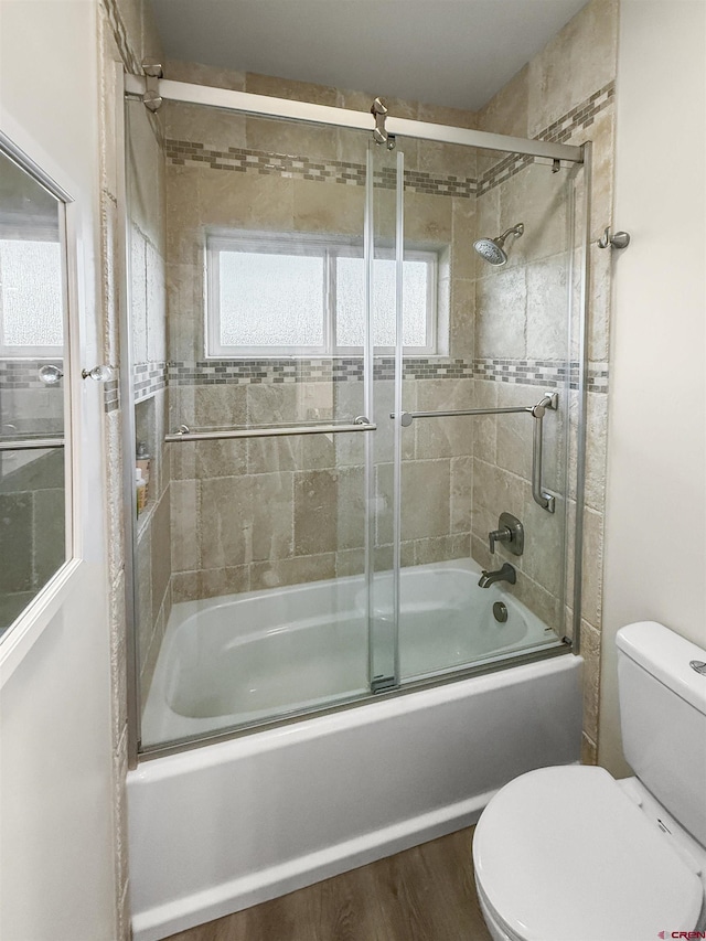 full bathroom featuring shower / bath combination with glass door, toilet, and wood finished floors