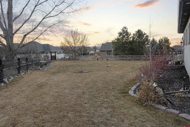 yard at dusk featuring fence