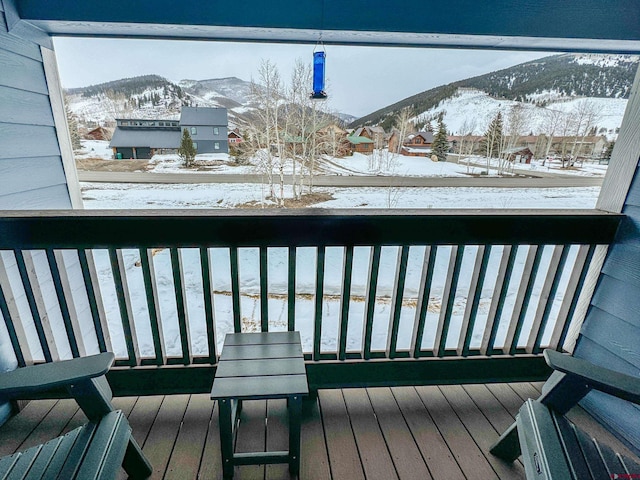 snow covered back of property with a mountain view