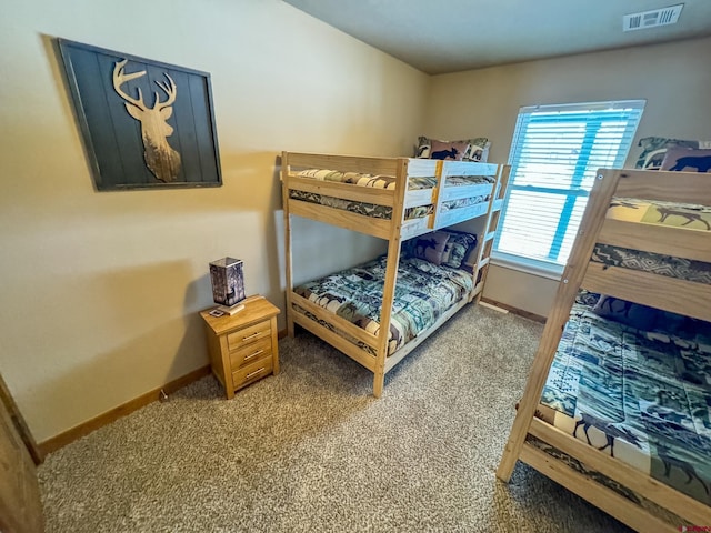 carpeted bedroom featuring visible vents and baseboards