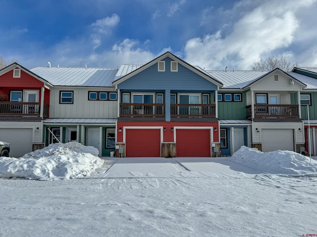 townhome / multi-family property featuring metal roof, a standing seam roof, an attached garage, and board and batten siding