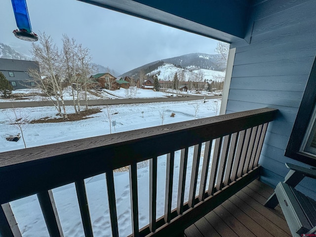 snow covered back of property with a mountain view