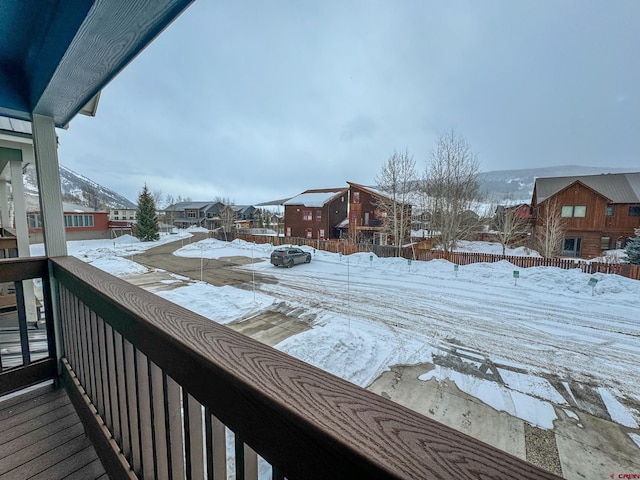 snow covered back of property featuring a residential view