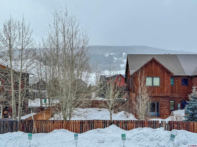 view of snowy exterior featuring fence