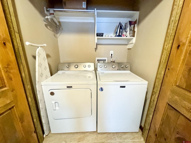 laundry area with laundry area, washer and clothes dryer, and light tile patterned flooring