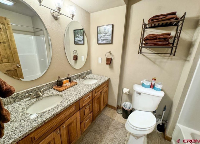 full bathroom with a shower, a sink, toilet, and double vanity